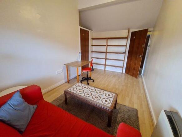 Bright furnished bedroom with a red sofa, patte...