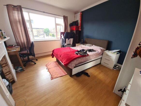 Bright double bedroom with a large window, wood...
