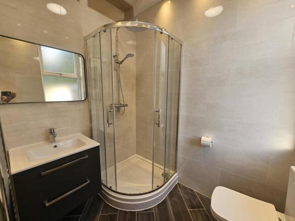 Bright, modern bathroom featuring a curved corn...