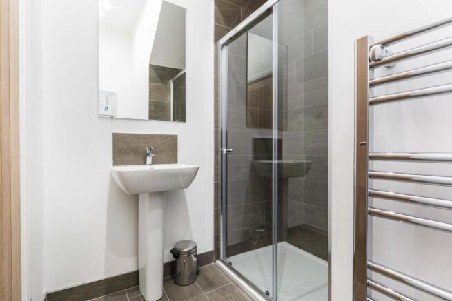 Modern ensuite bathroom with a glass shower cub...