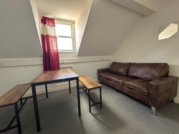 A cozy living room featuring a rich brown leath...