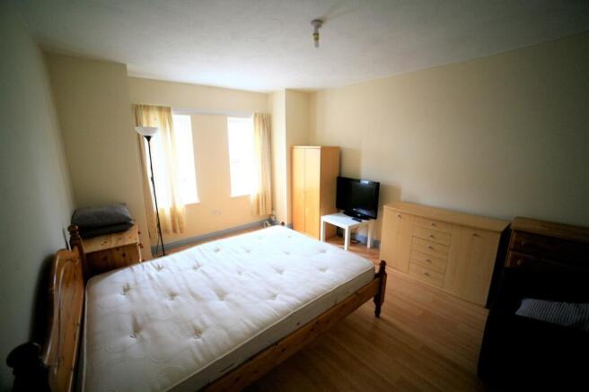 Spacious double bedroom featuring large windows...