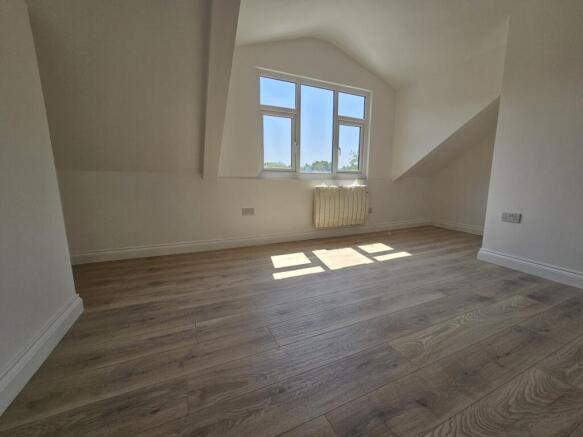 Bright top-floor bedroom with light wood floori...