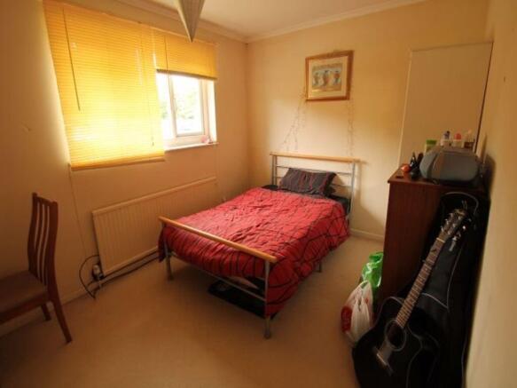 Warm, tidy double bedroom with a metal bed fram...