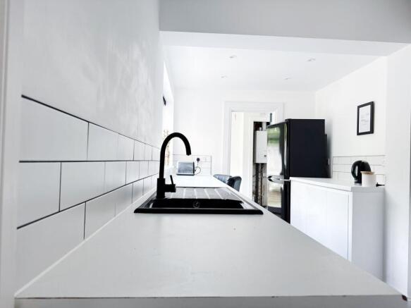 Bright, modern galley-style kitchen with white ...