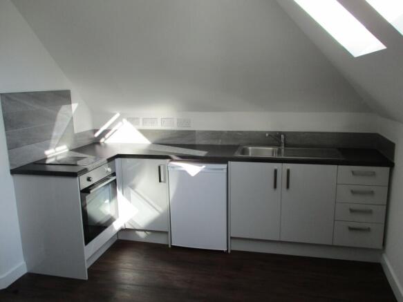 Modern kitchen area featuring a sleek black cou...