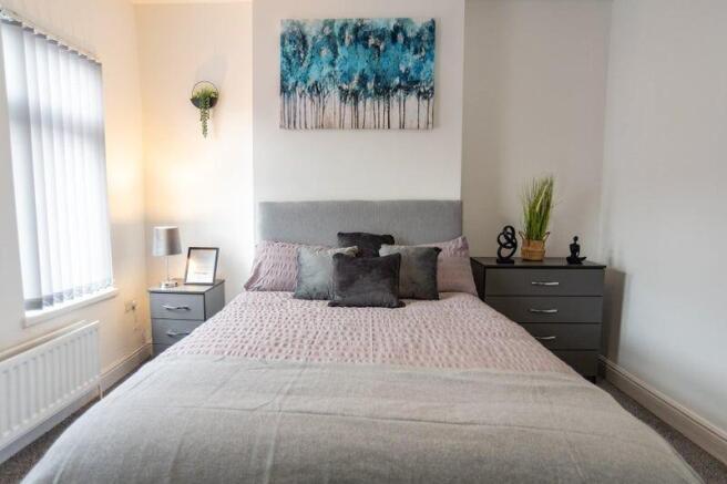 Bright, neatly styled double bedroom with a com...