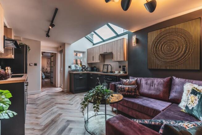 Stylish open-plan living area with a plush purp...