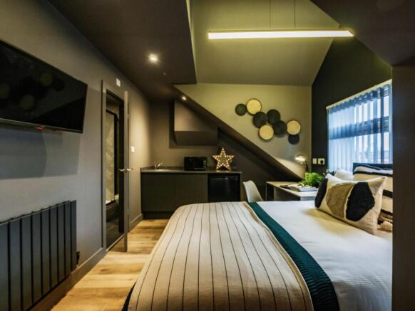 A spacious and stylish master bedroom featuring...