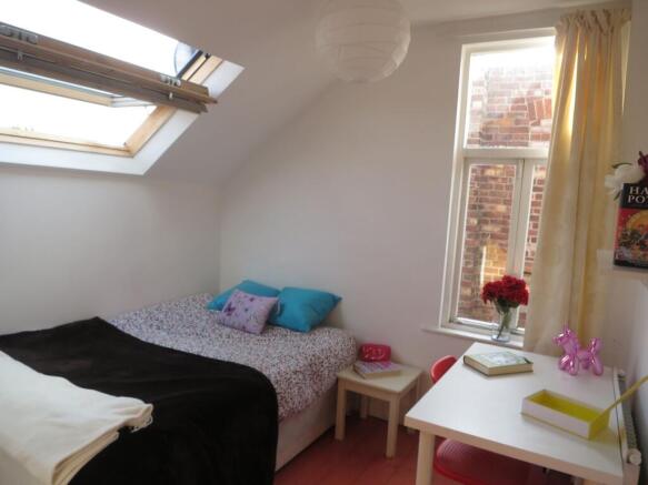 Bright and cozy bedroom featuring natural light...