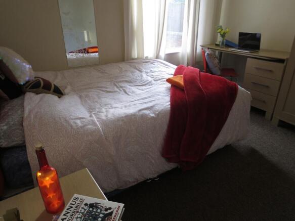 Spacious master bedroom featuring a large bed w...