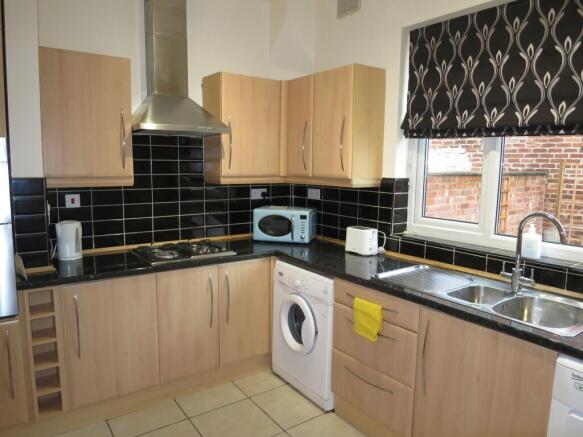 A modern kitchen featuring wooden cabinetry, bl...