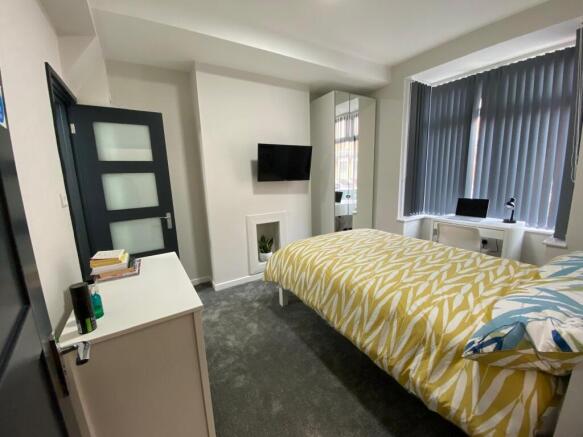 Bright, neatly furnished double bedroom with a ...