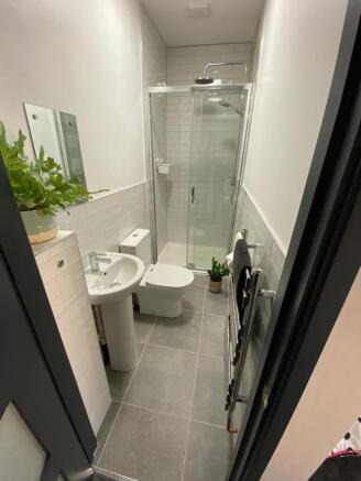 Modern tiled bathroom with a glass-enclosed sho...
