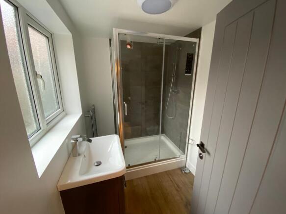 A neat and modern bathroom featuring a glass-en...