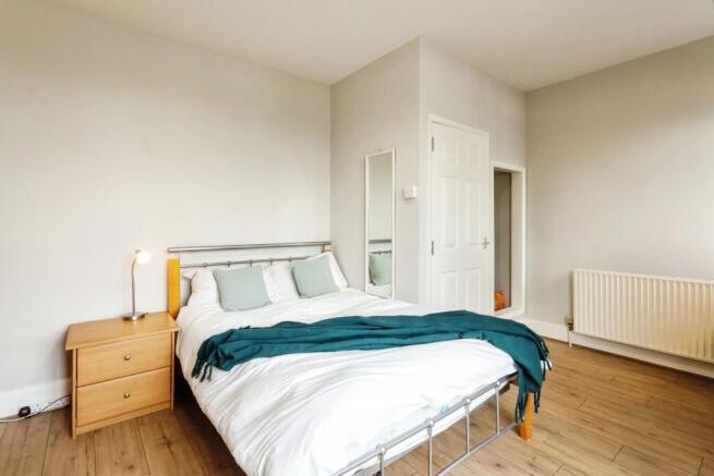 A bright, attractively decorated bedroom featur...