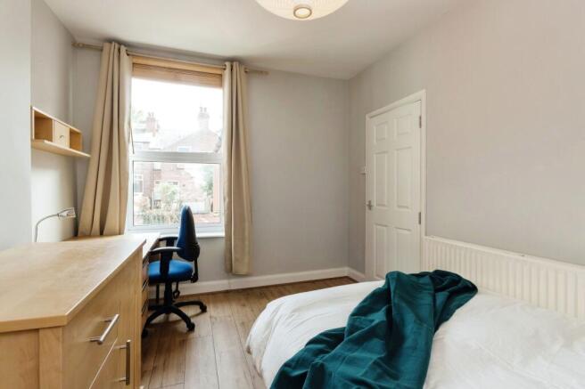 Bright and tidy bedroom featuring a comfortable...