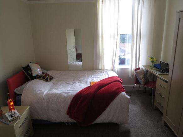 Bright and inviting bedroom featuring a cozy be...