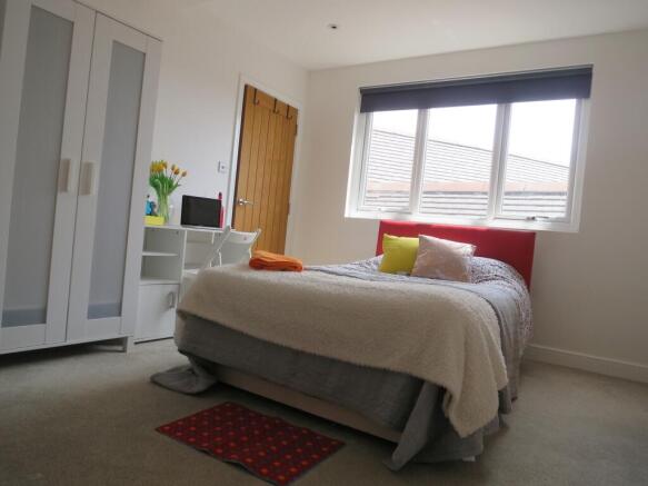 A bright and inviting double bedroom with moder...