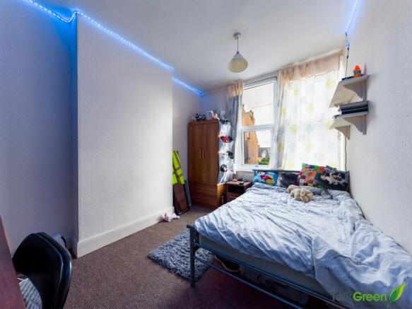 A cozy bedroom featuring a single bed with colo...