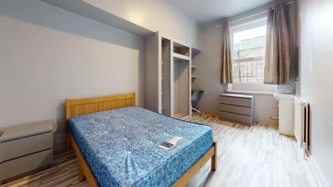 A bright and tidy double bedroom featuring a wo...