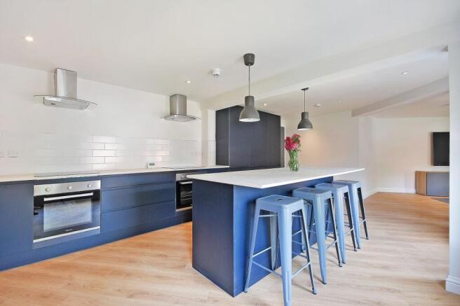 Bright and modern kitchen featuring sleek navy ...