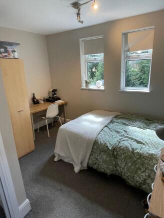 A cozy, well-lit bedroom with a double bed, two...