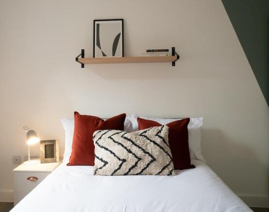 A stylish and spacious master bedroom featuring...