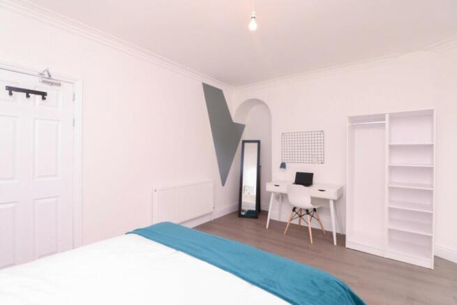 A bright and stylish double bedroom featuring a...