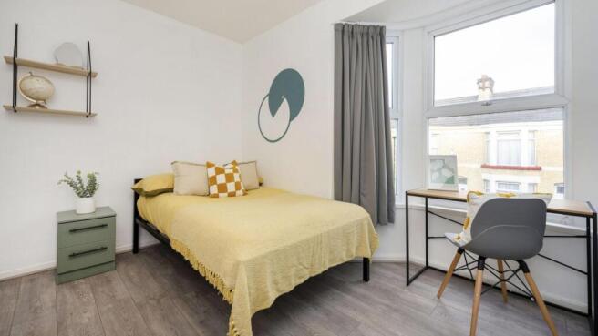 A bright and cozy double bedroom featuring a co...