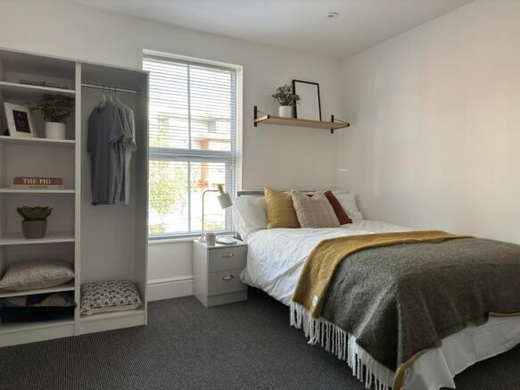 A bright and inviting double bedroom with styli...