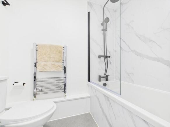 Bright, modern bathroom featuring a white bath ...