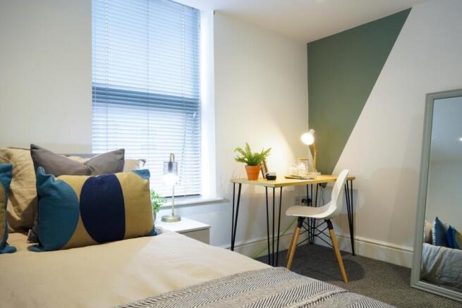 A bright and inviting double bedroom featuring ...