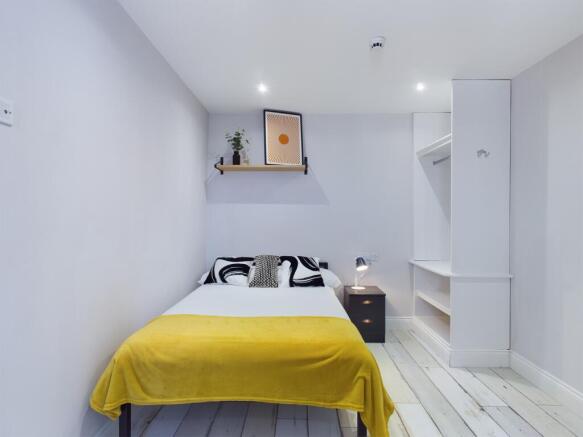 A bright and tidy bedroom featuring a comfortab...
