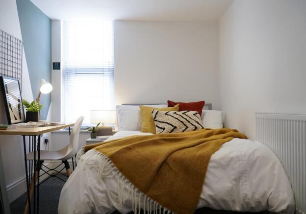 A bright, inviting bedroom with ample natural l...