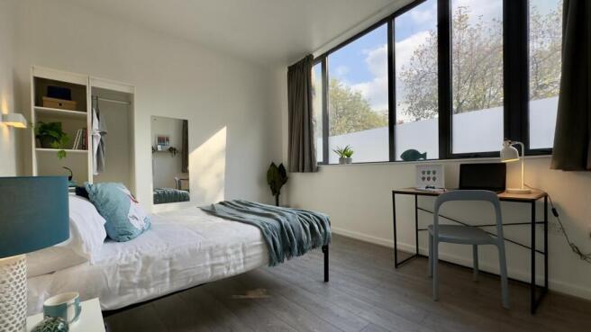 A bright and modern double bedroom featuring la...