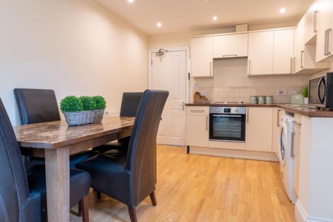 Bright, modern kitchen-dining area with wooden ...