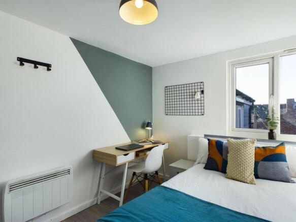 A bright and inviting double bedroom featuring ...
