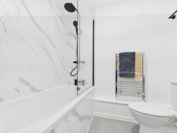 Bright modern bathroom with a bathtub and overh...