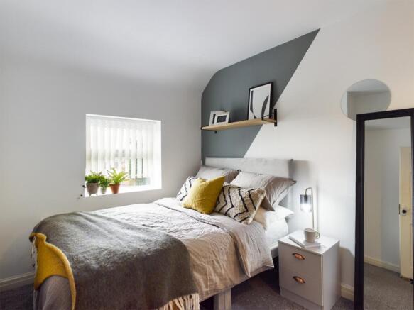 A bright and inviting double bedroom with styli...