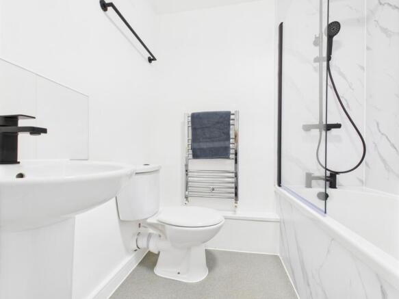 Bright, modern bathroom with white fixtures, a ...
