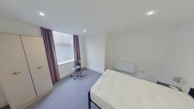 A spacious and well-lit double bedroom featurin...