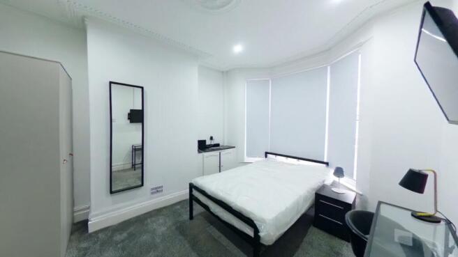 A bright and spacious double bedroom with moder...