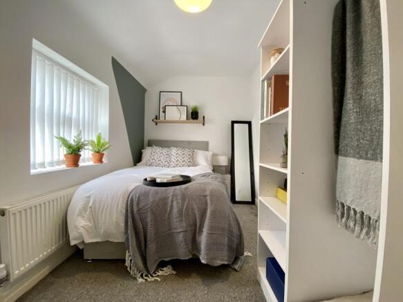 A bright and inviting double bedroom with styli...