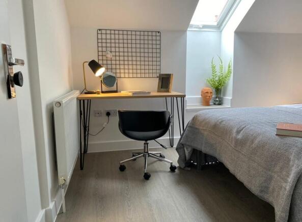 A bright and tidy single bedroom featuring a co...