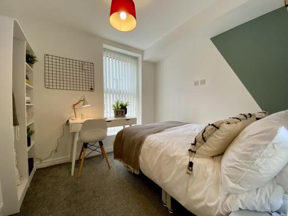 A bright and inviting double bedroom featuring ...