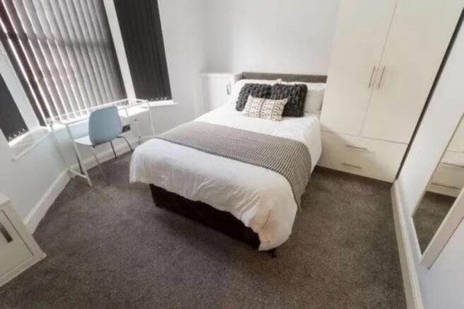 A bright and inviting double bedroom featuring ...