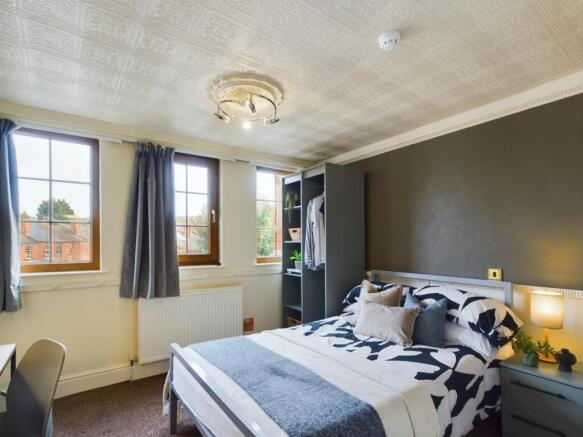 A bright and inviting double bedroom with ample...