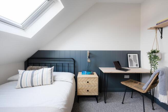 A bright and stylish double bedroom featuring a...