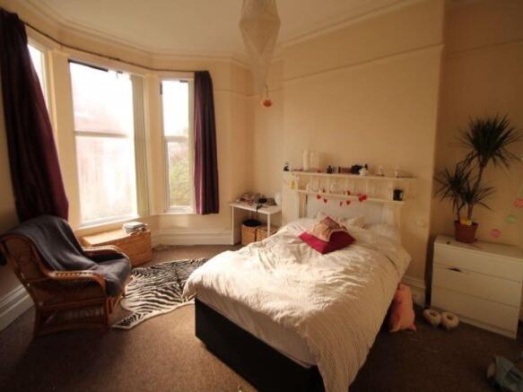 A bright and cozy master bedroom featuring a co...